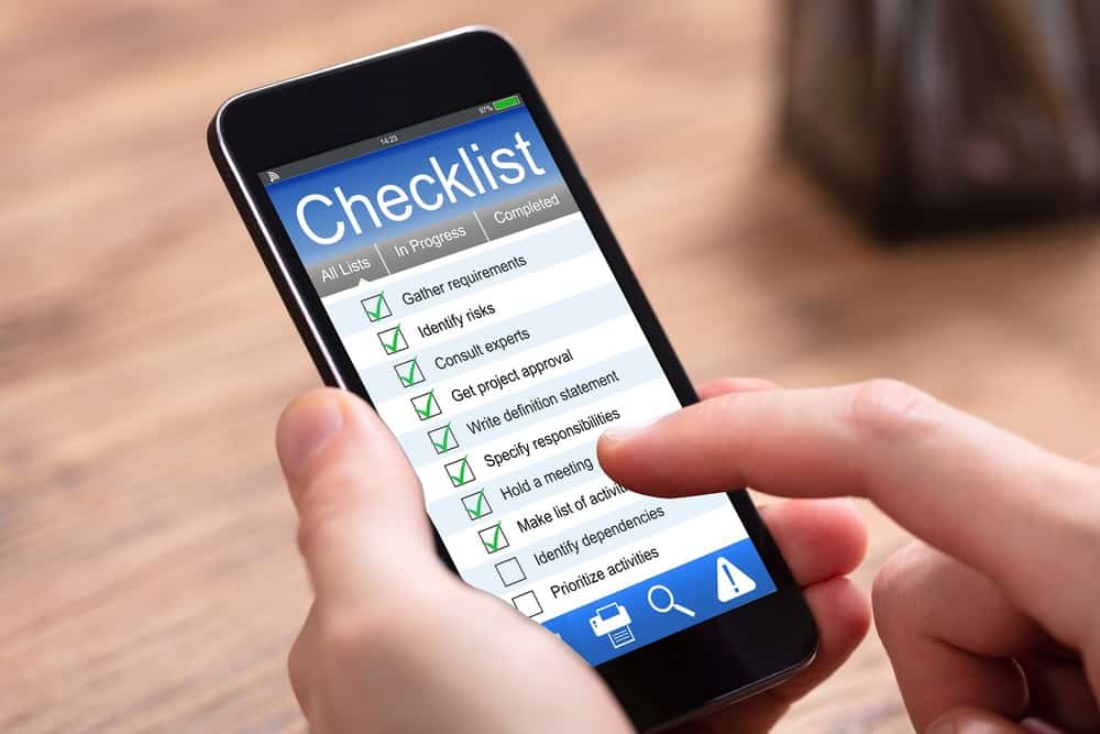 Person filling checklist form on cellphone