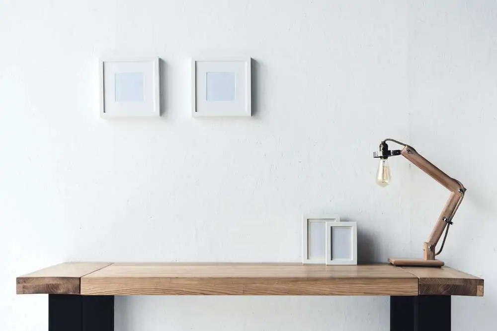 Clean study table with lamp and phot frames on the side