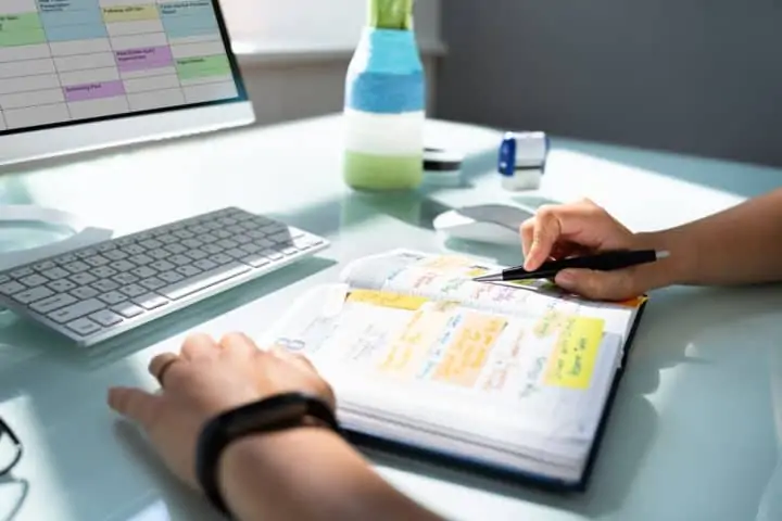 Businessman looking at calendar schedule and agenda in an appointment organizer