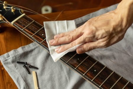 Close up image of hand wiping guitar fret