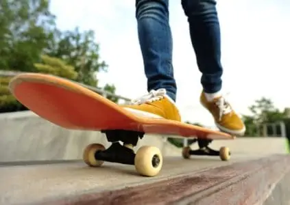 close-up image of skateboard with man riding on it