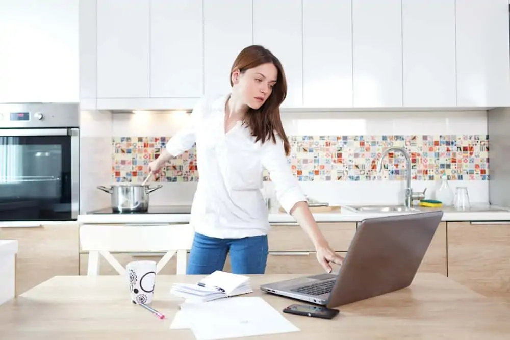 Woman multitasking and using her laptop