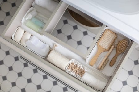 Opened drawer under bathroom sink with toiletries
