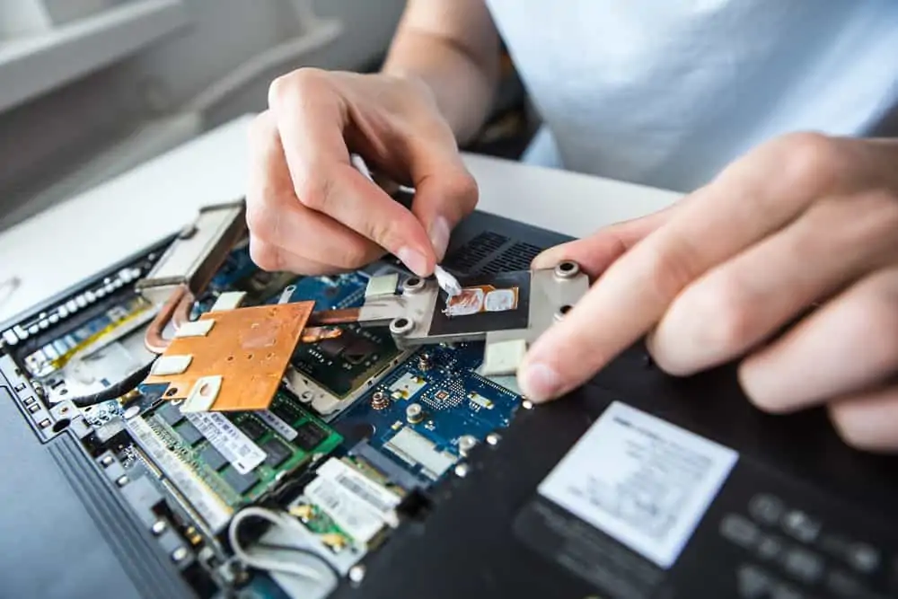 Close-up image of hand removing thermal paste from CPU