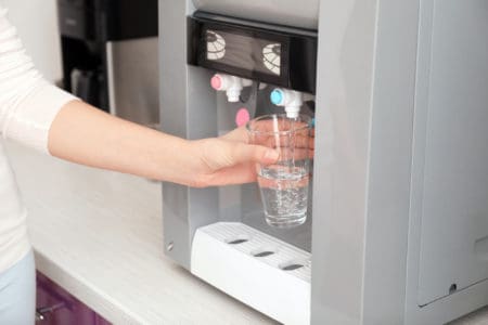 Woman filling a glass from a water cooler