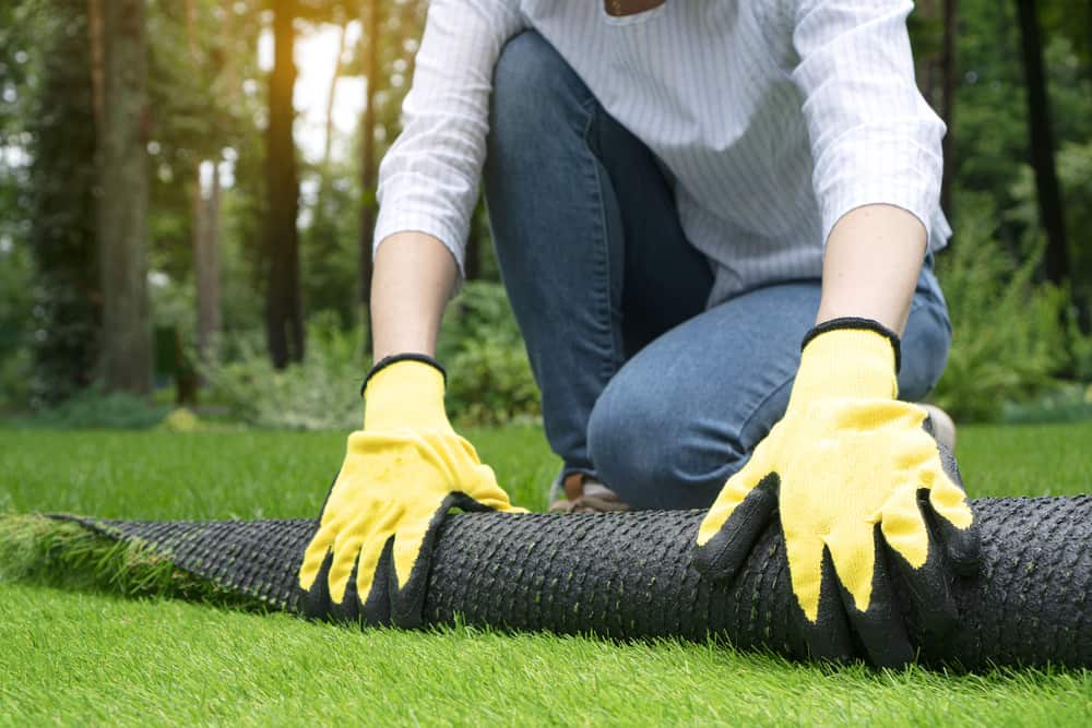Person doing a green lawn with artificial grass