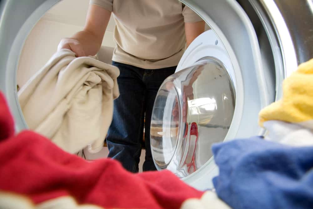 Man putting clothes inside the washer