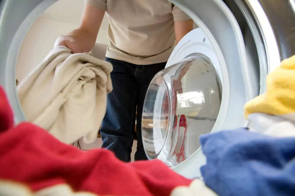 Man putting clothes inside the washer