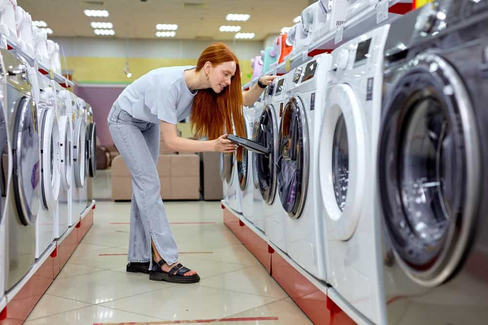 Woman choosing washer in supermarket