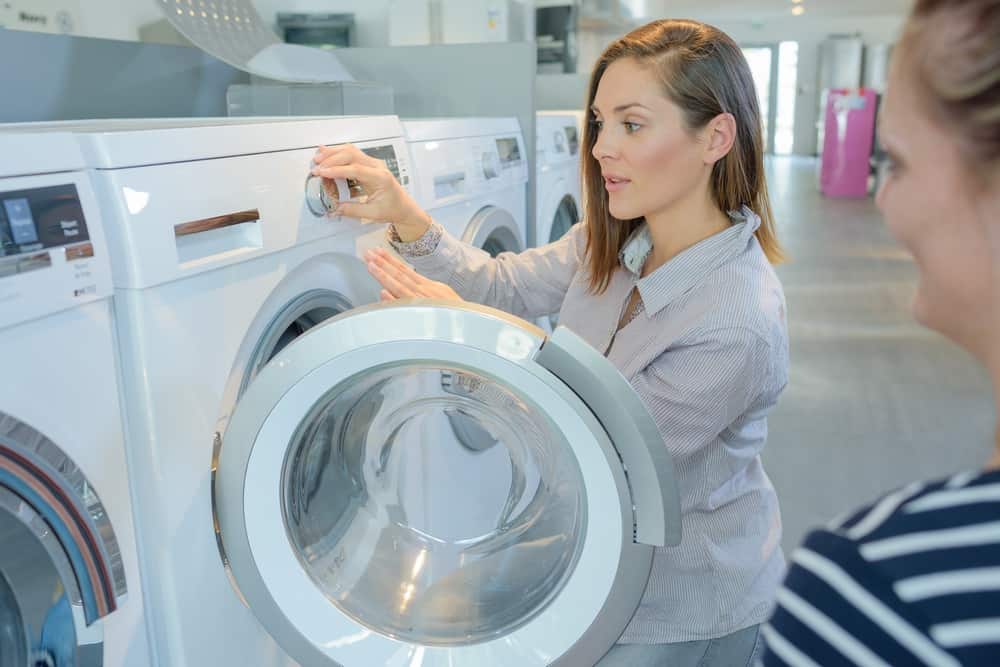 Woman demonstrating washer to a lady customer