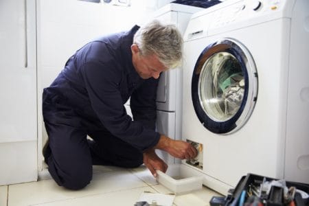 Plumber fixing washing machine