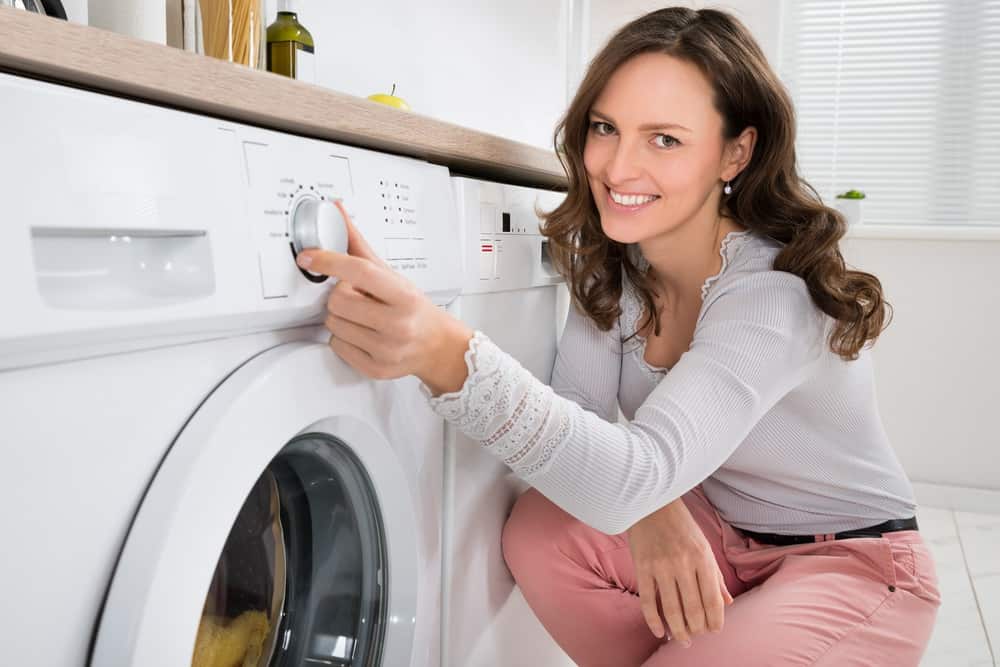 Woman setting the wash cycle of a high-efficiency front load washer