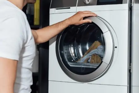 Man holding lid of washer
