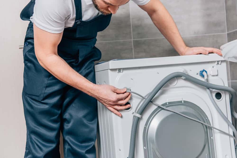 Repairman disconnecting washing machine