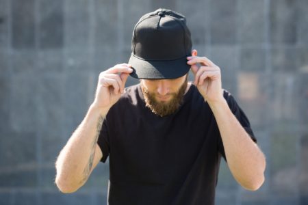 Male with beard wearing black baseball cap