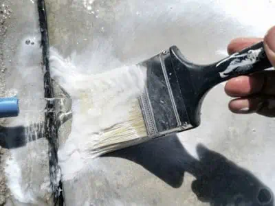 Cleaning paintbrush with excess paint under stream of water