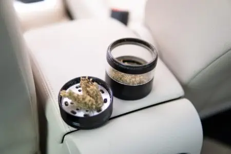 Grinder with cannabis inside of white car