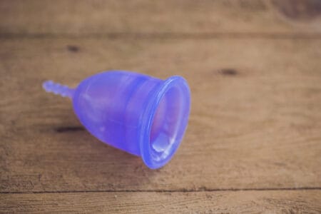 Menstrual cup on wooden background