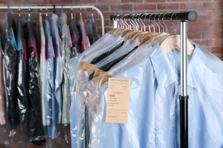Rack of clean clothes hanging on hangers at dry-cleaning