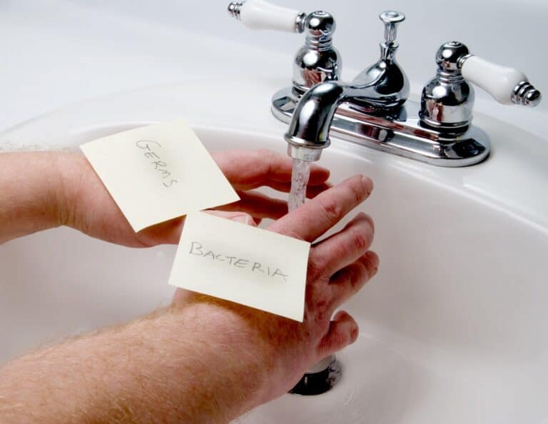 Person washing hands with germs and bacteria in the sink