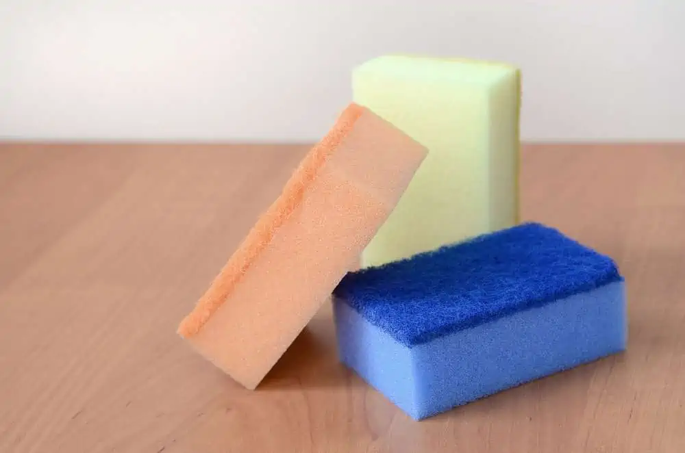 Colorful kitchen sponges on top of wooden countertop