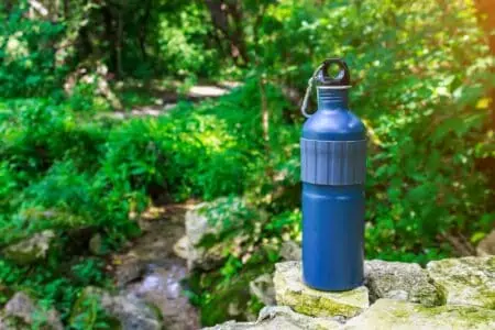 Hydro flask on top of rocks in spring forest nature