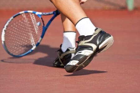 Tennis player legs and feet on court playing