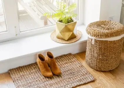 Jute mat with boots on top and basket beside