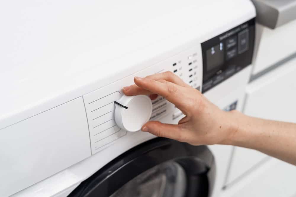 Female hand selecting program at Samsung washing machine