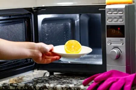 Housewife cleaning microwave oven using lemon