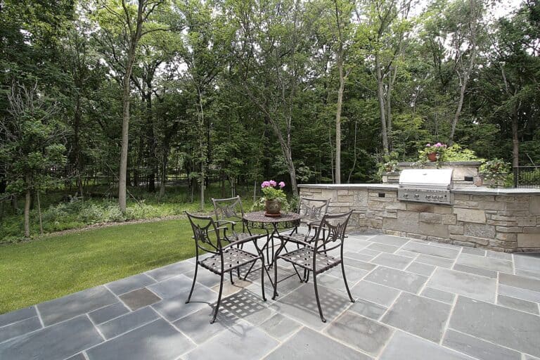 Bluestone patio and stone grill outside luxury home