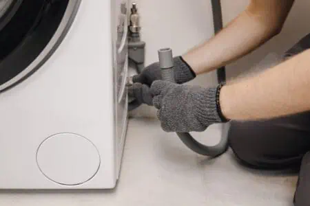 plumber removing laundry drain to get rid of smell